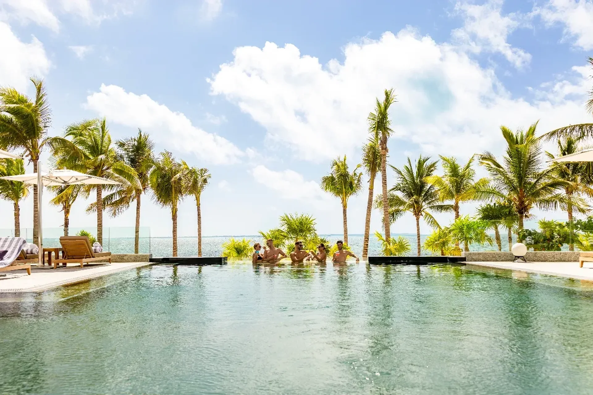 Grupo de amigos disfrutando la alberca infinita de Hotel Mousai Cancún