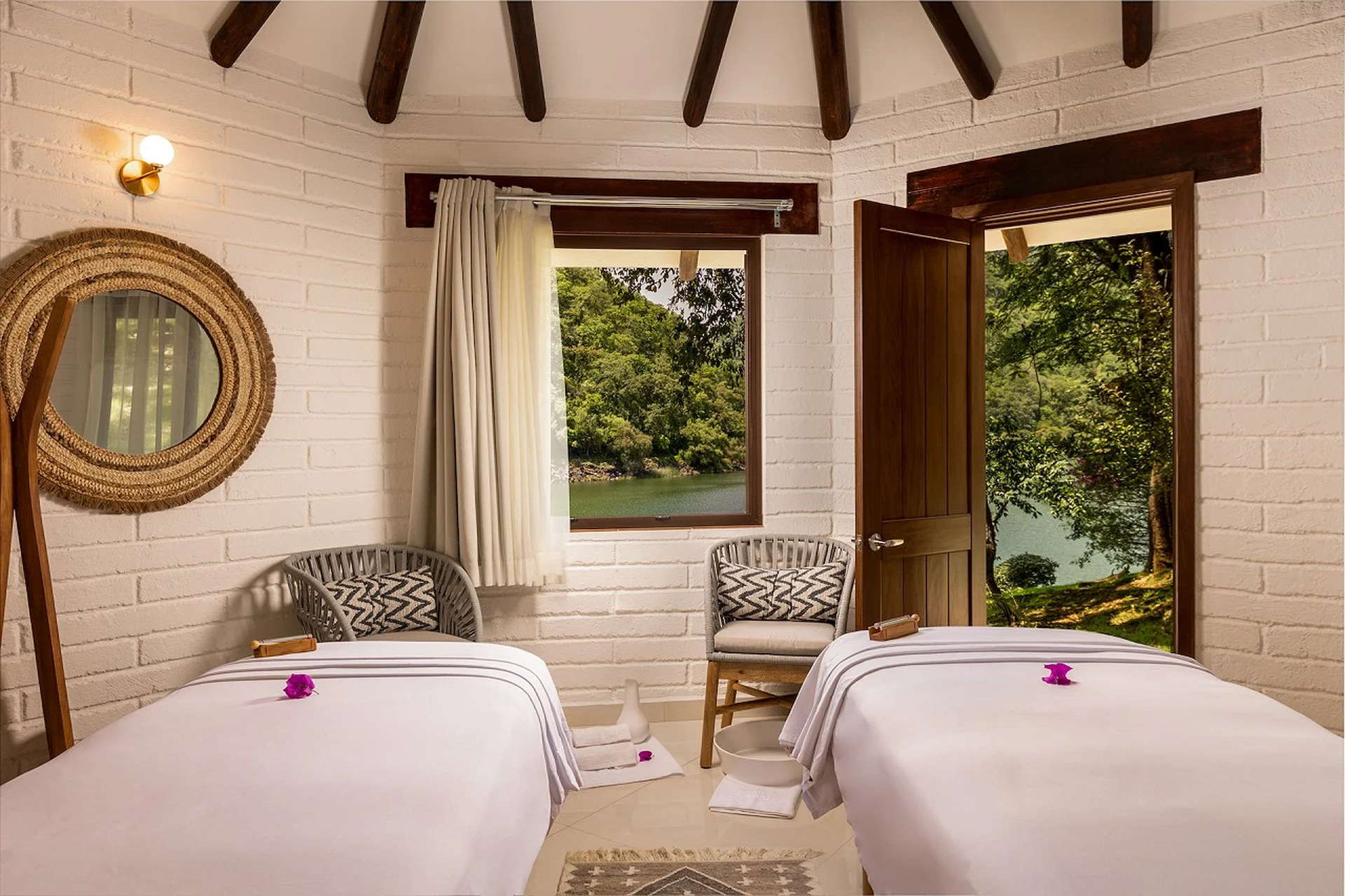 Sofas and armchairs in the lounge facing the lake and forested hills