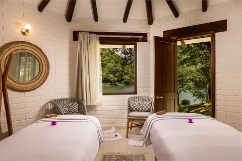 Sofas and armchairs in the lounge facing the lake and forested hills