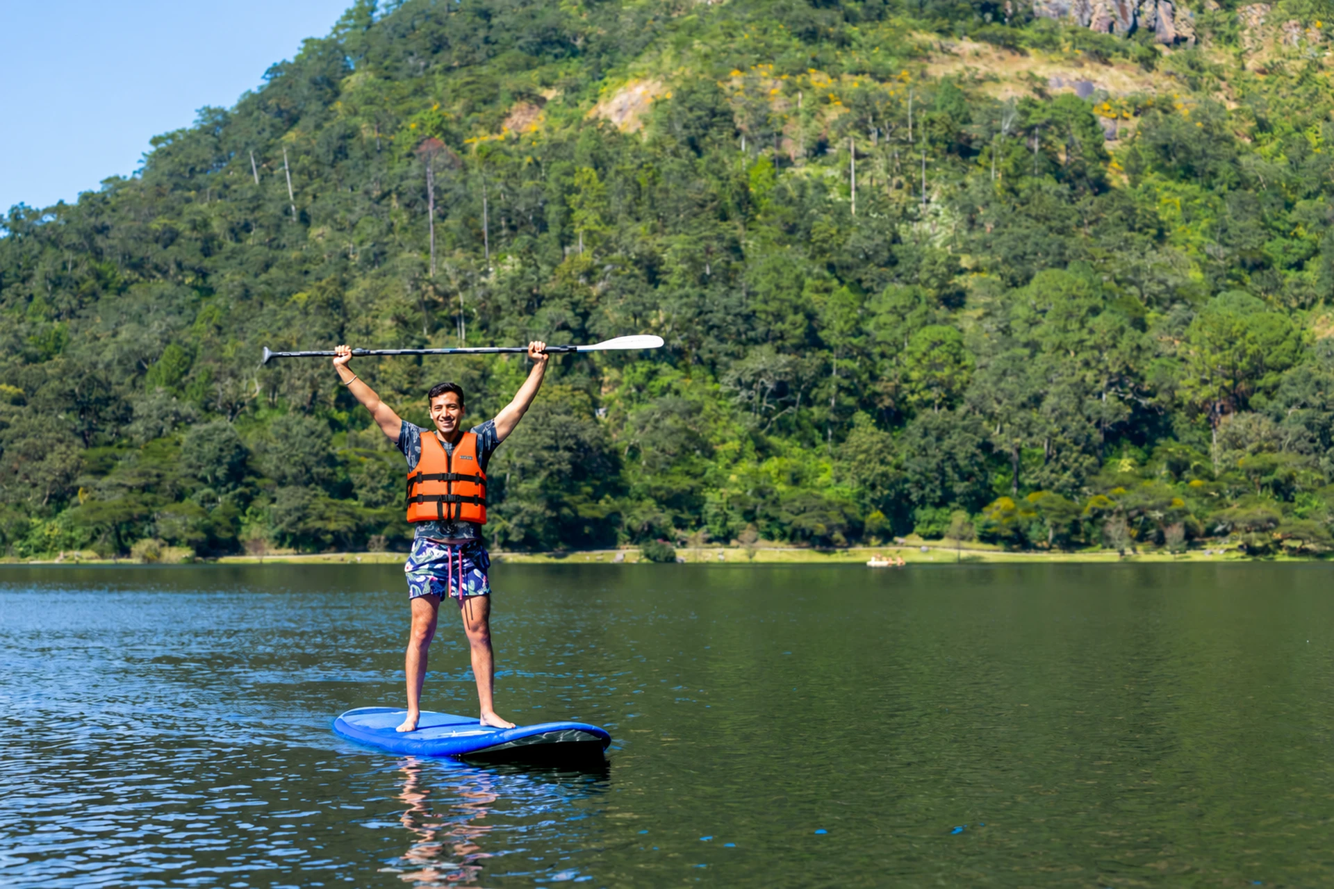 Triumphant Paddleboarder on a Mountain Lake