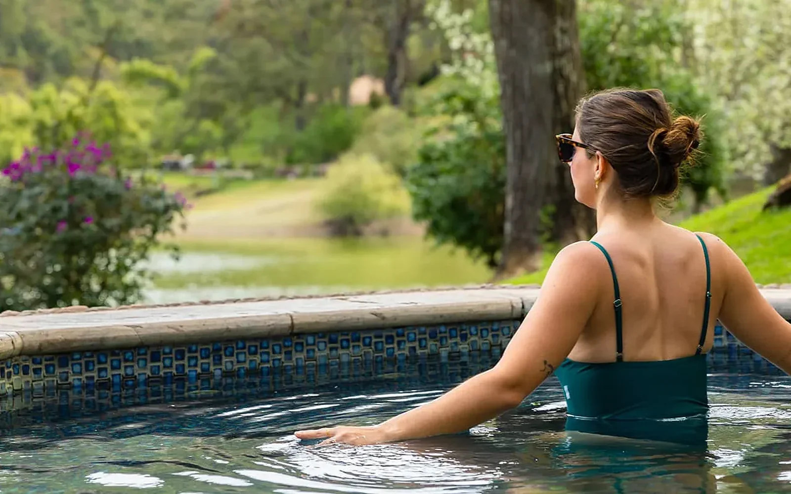 Guest enjoying the outdoor hot tub surrounded by nature