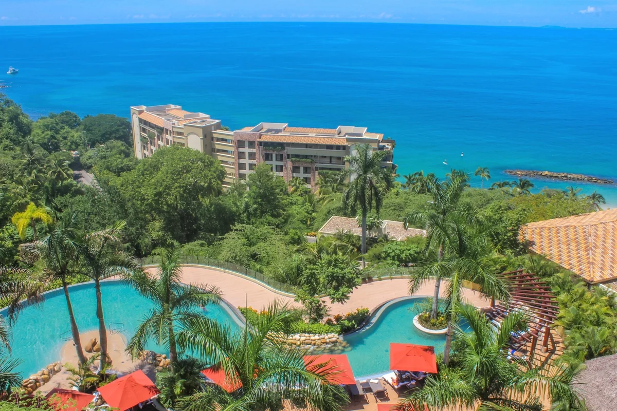 Aerial view of the pools surrounded by jungle above Banderas Bay at Garza Blanca Puerto Vallarta