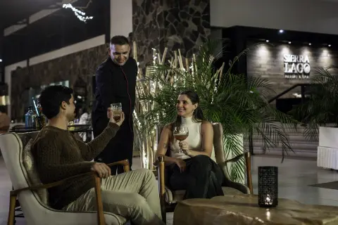 Sierra Lago Resort & Spa - Couple enjoying drinks served by staff in the resort lounge at night