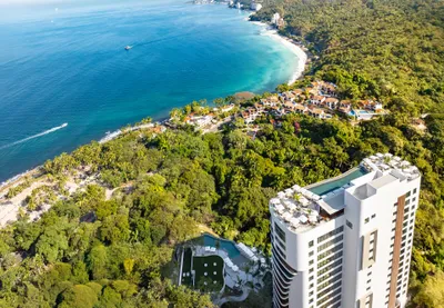 Aerial panoramic view of Garza Blanca Sanctuary oceanfront resort between the Pacific Ocean and the Sierra Madre mountains in Puerto Vallarta.