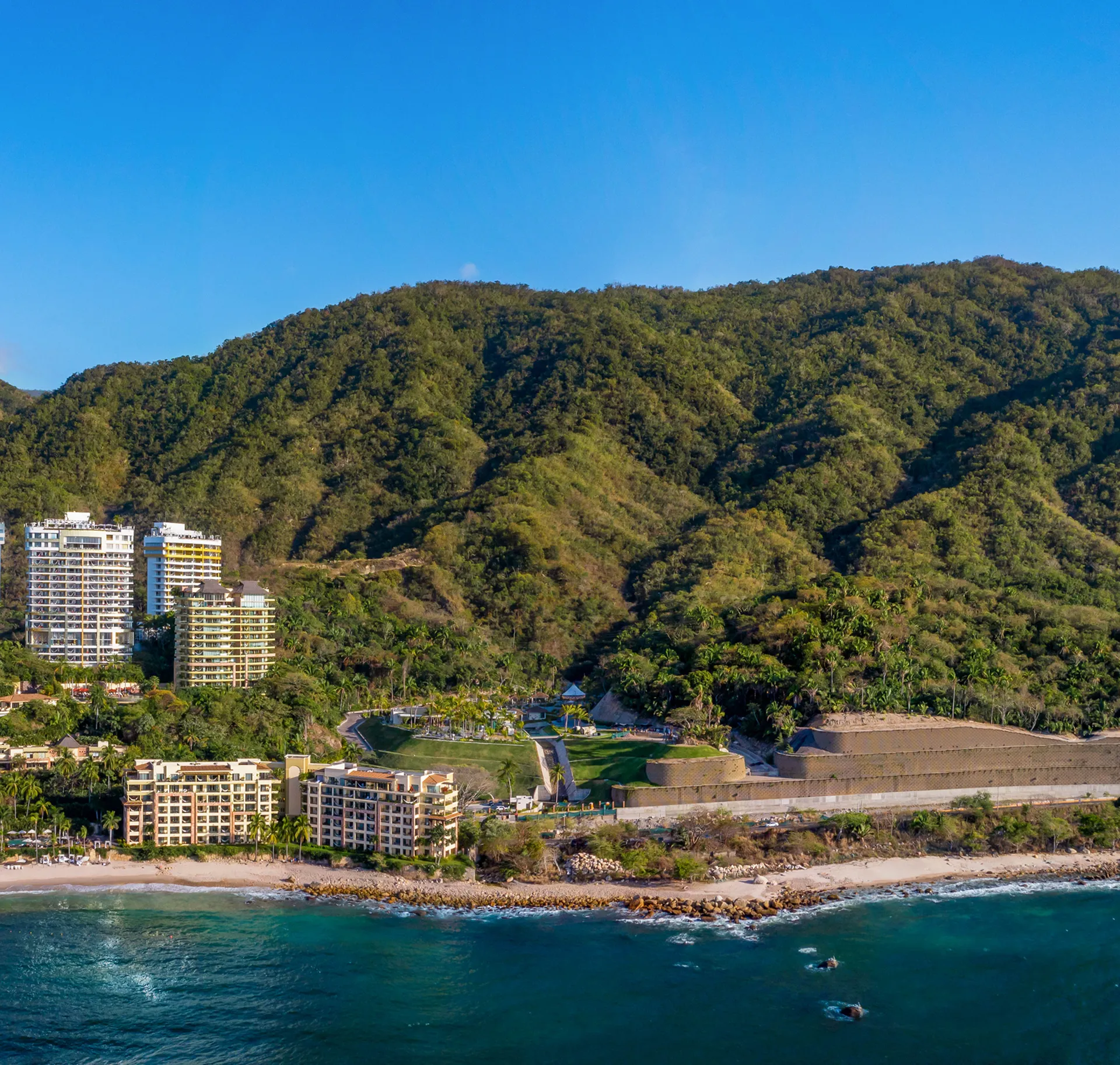 Guest relaxing by a pool surrounded by lush jungle foliage
