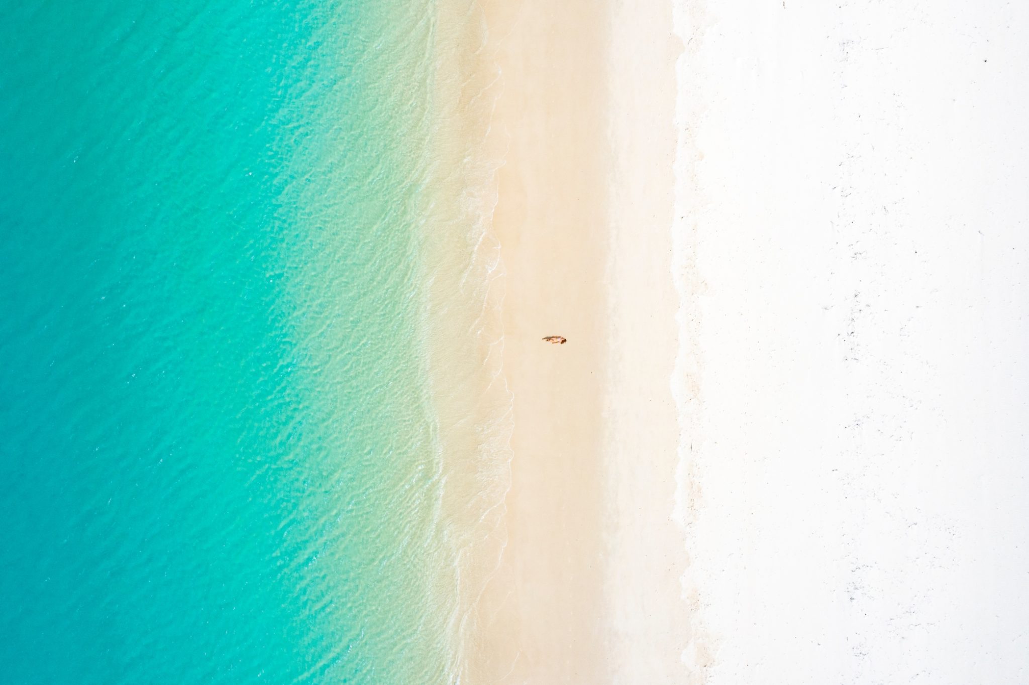 woman-lying-on-white-sand-beach-with-turquoise-waters-in-cancun