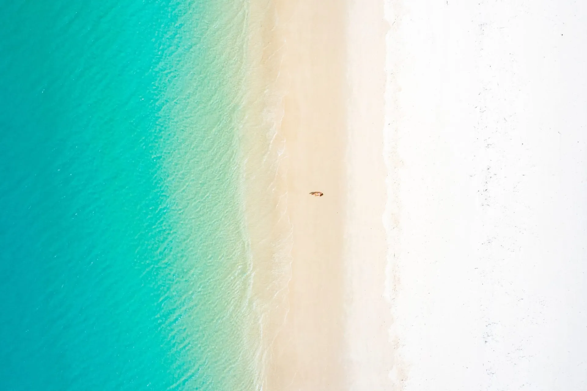 woman-lying-on-white-sand-beach-with-turquoise-waters-in-cancun
