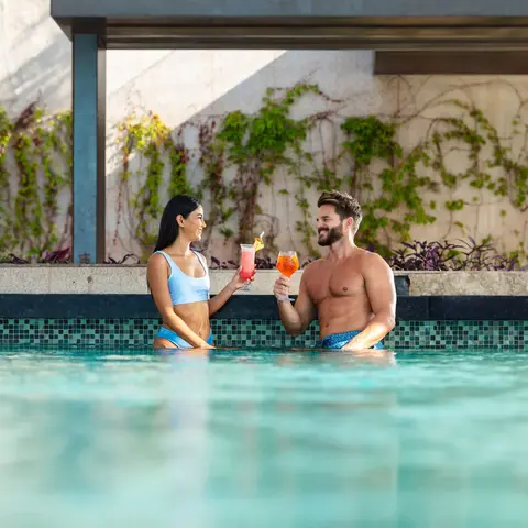 Couple enjoying cocktails at the swim-up pool bar at Garza Blanca Los Cabos