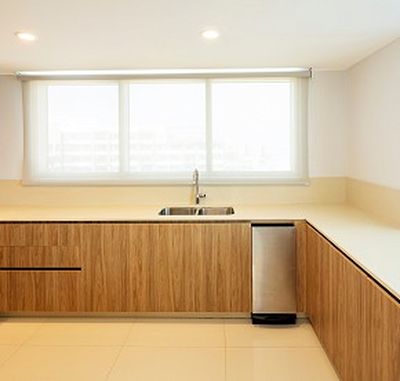 Modern kitchen with wooden cabinets, a stainless steel sink, and a large window. Bright lighting and minimalistic design.