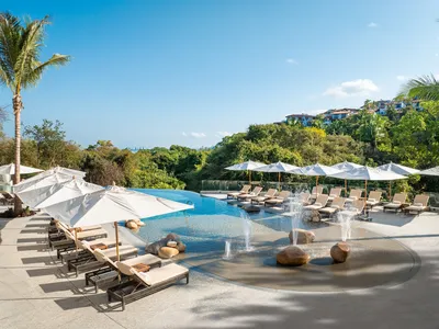 River-side pool at Garza Blanca Sanctuary surrounded by tropical greenery and lounge areas under the Puerto Vallarta sky.