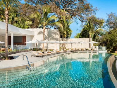 River-side pool at Garza Blanca Sanctuary surrounded by tropical greenery and lounge areas under the Puerto Vallarta sky.