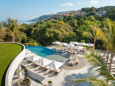 River-side pool at Garza Blanca Sanctuary surrounded by tropical greenery and lounge areas under the Puerto Vallarta sky.