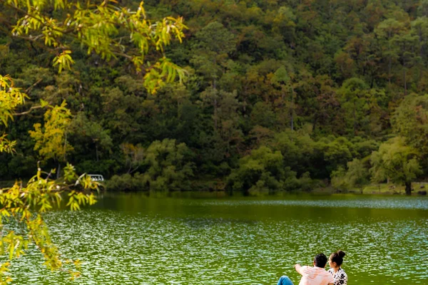 Sierra Lago Resort & Spa - Couple sitting on a dock over the green lake waters with mountain views