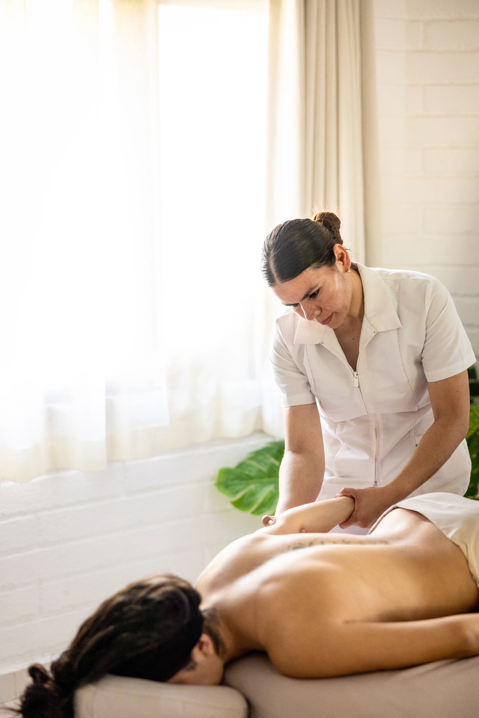 Sierra Lago Resort & Spa - Vertical view of a therapist giving a relaxing massage in a bright room