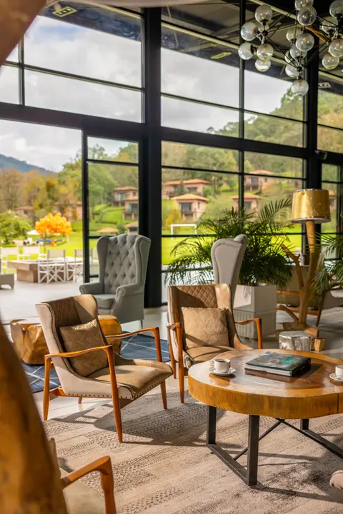 Sierra Lago Resort & Spa - Armchairs and wooden coffee table in the glass lounge with views of the cabins