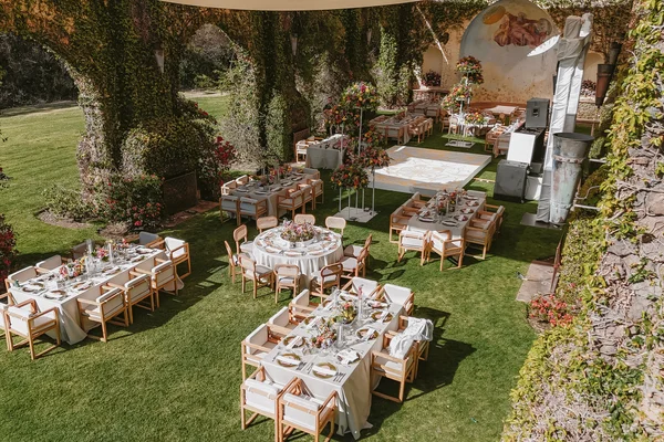 Ceremonia con invitados sentados frente al altar bajo un árbol junto al lago