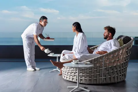 Couple in robes being served on an ocean-view terrace at Spa Imagine, Garza Blanca Los Cabos