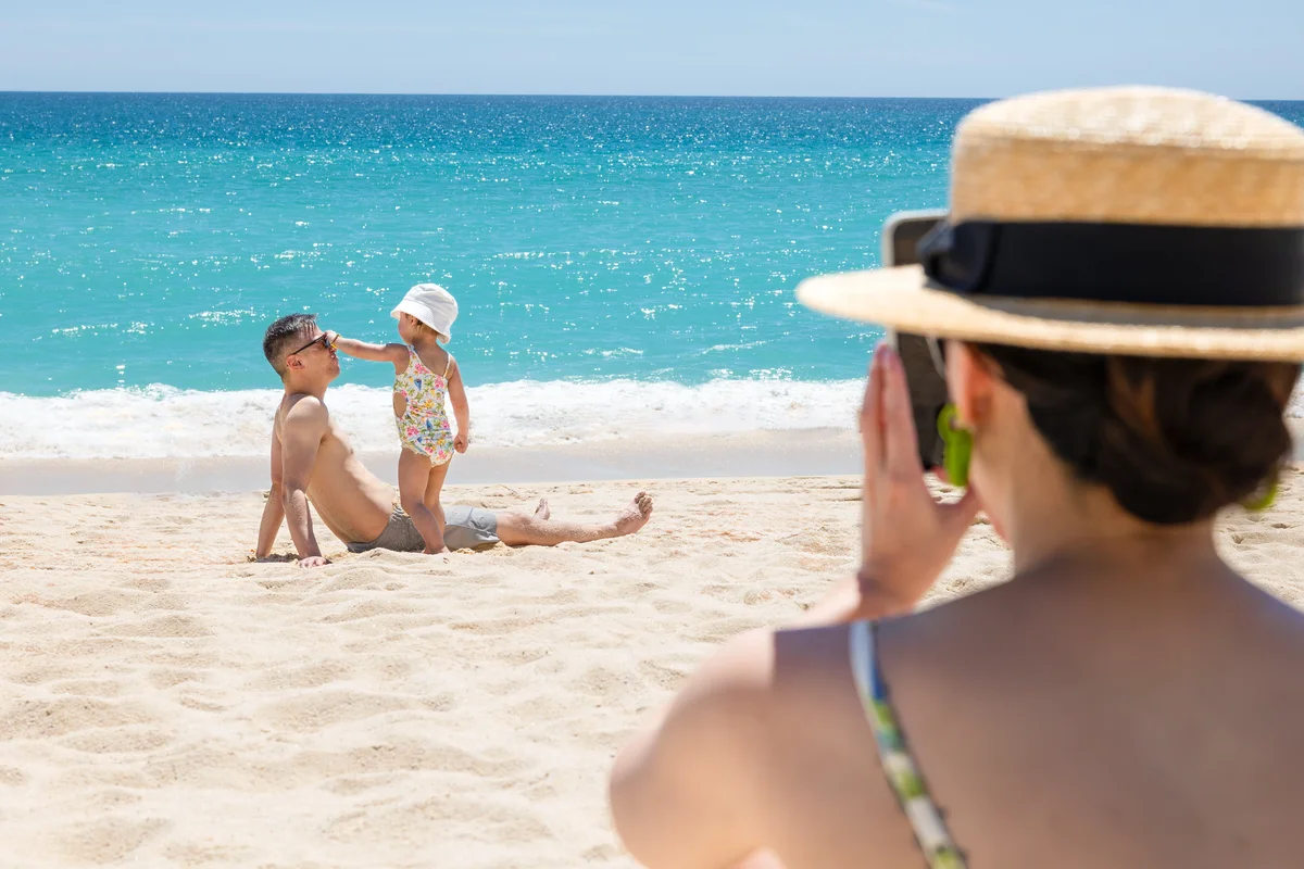 Mother photographing her kids on the beach at Garza Blanca Los Cabos