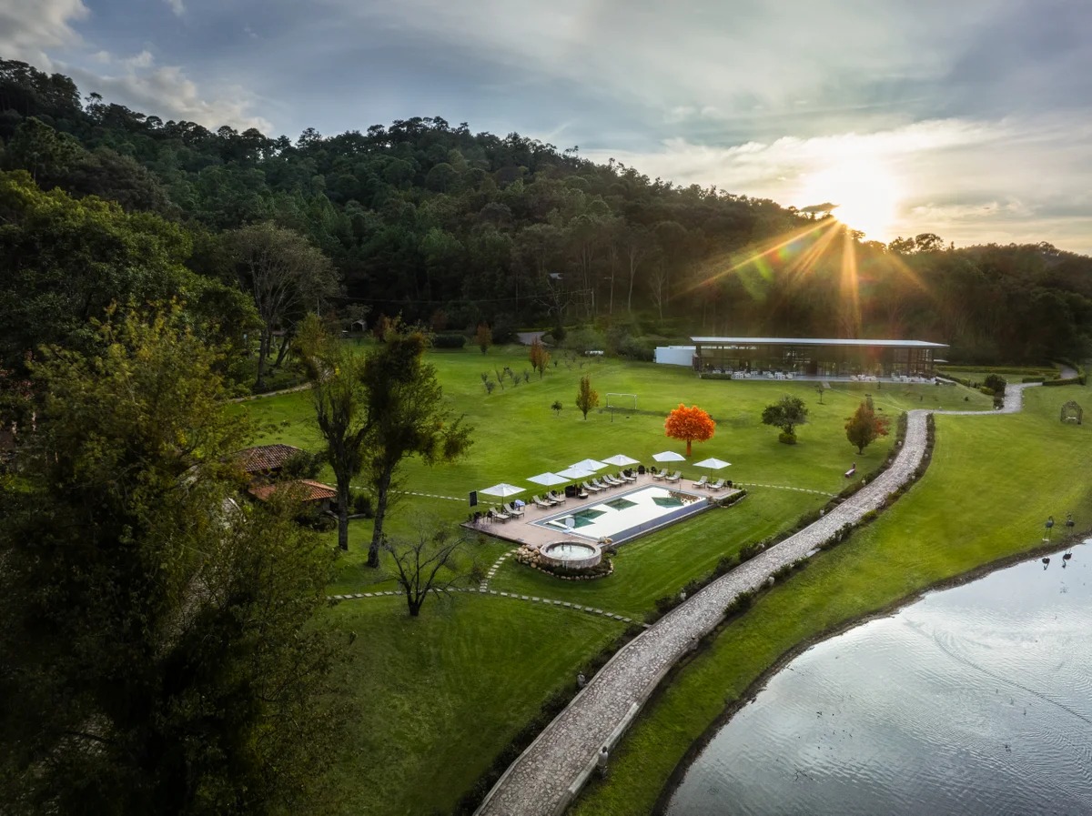 Vista aérea de los jardines, la alberca y la laguna al atardecer
