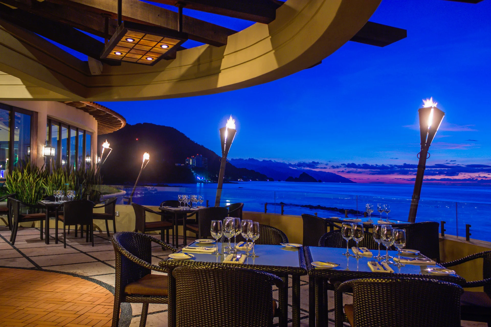 Blanca Blue restaurant terrace lit at dusk overlooking Banderas Bay at Garza Blanca Puerto Vallarta