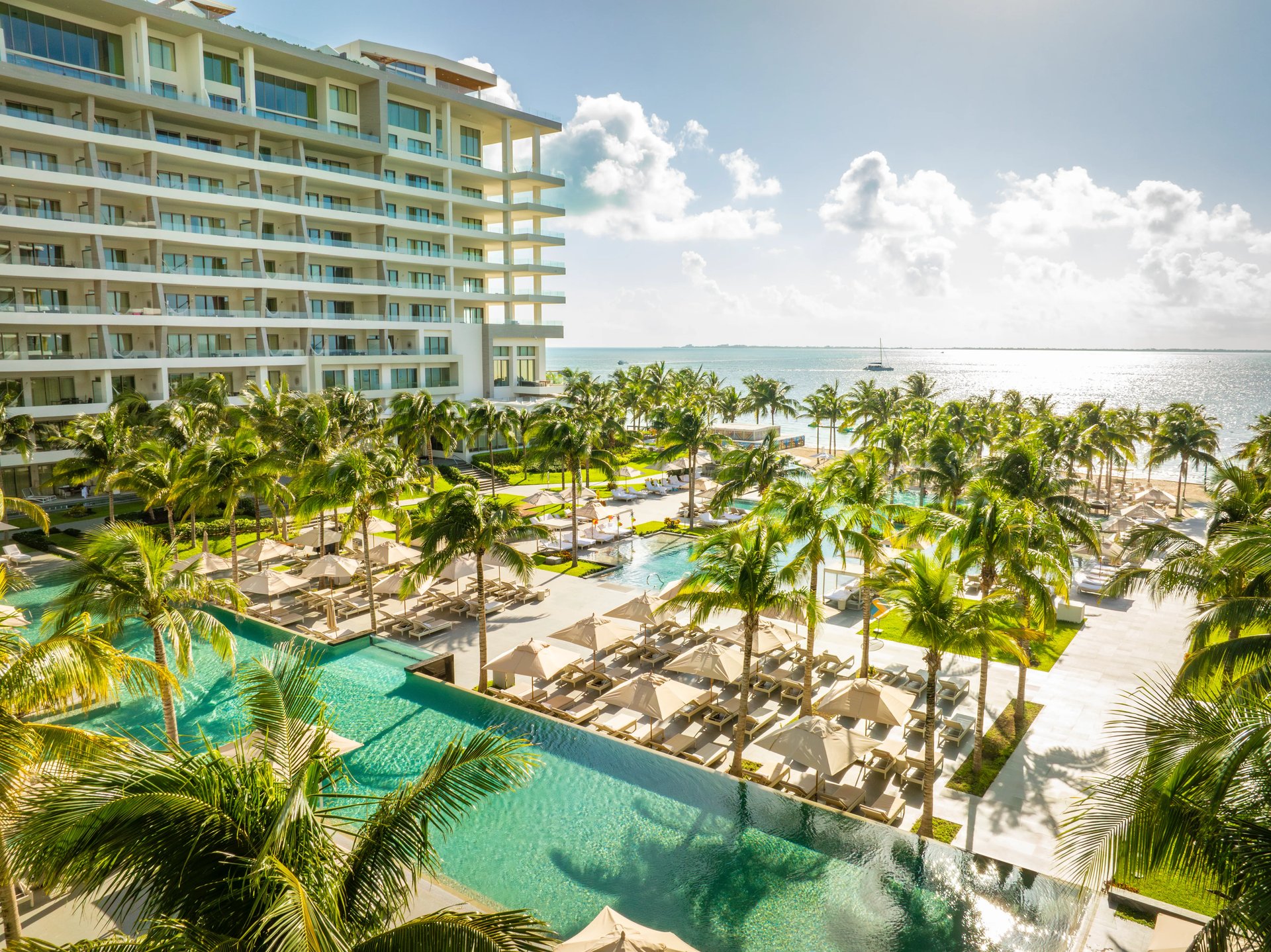 Garza Blanca luxury all-inclusive beach resort in Mexico: palm-fringed pool deck, sun loungers, and oceanfront views over the turquoise sea.