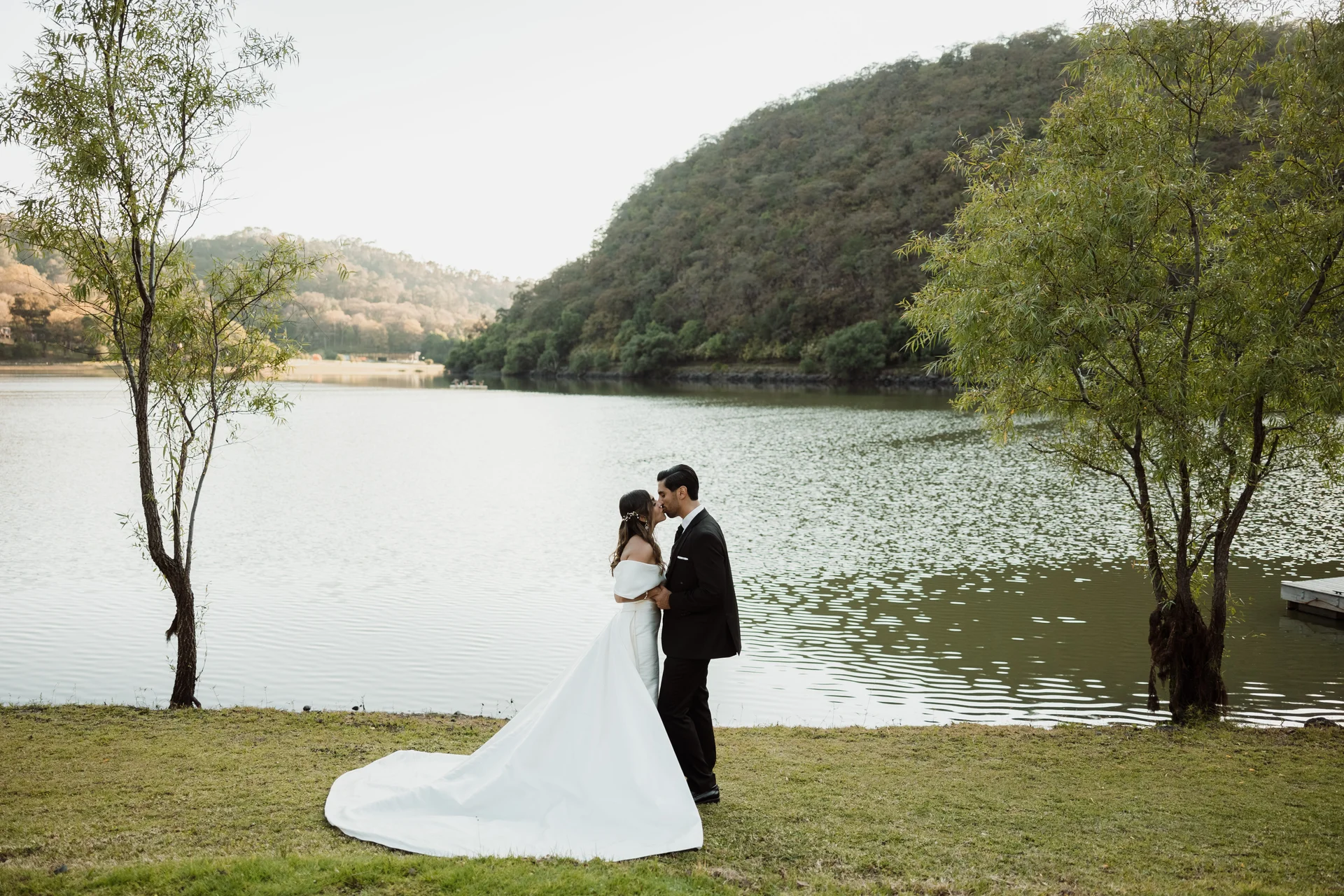 Banquet table set under an ivy arch with lake views