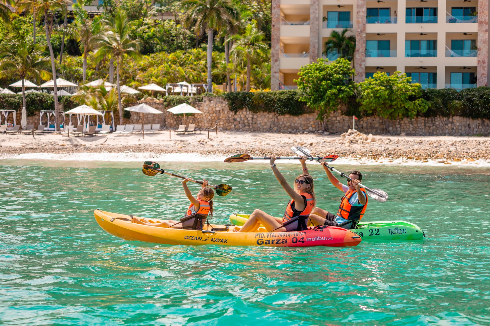 Guests kayaking in turquoise water in front of the beach at Garza Blanca Puerto Vallarta