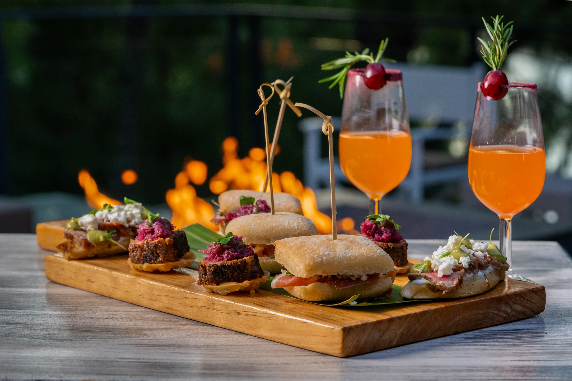 Sierra Lago Resort & Spa - Wooden board with mini sandwiches and canapés next to cocktails by the firepit
