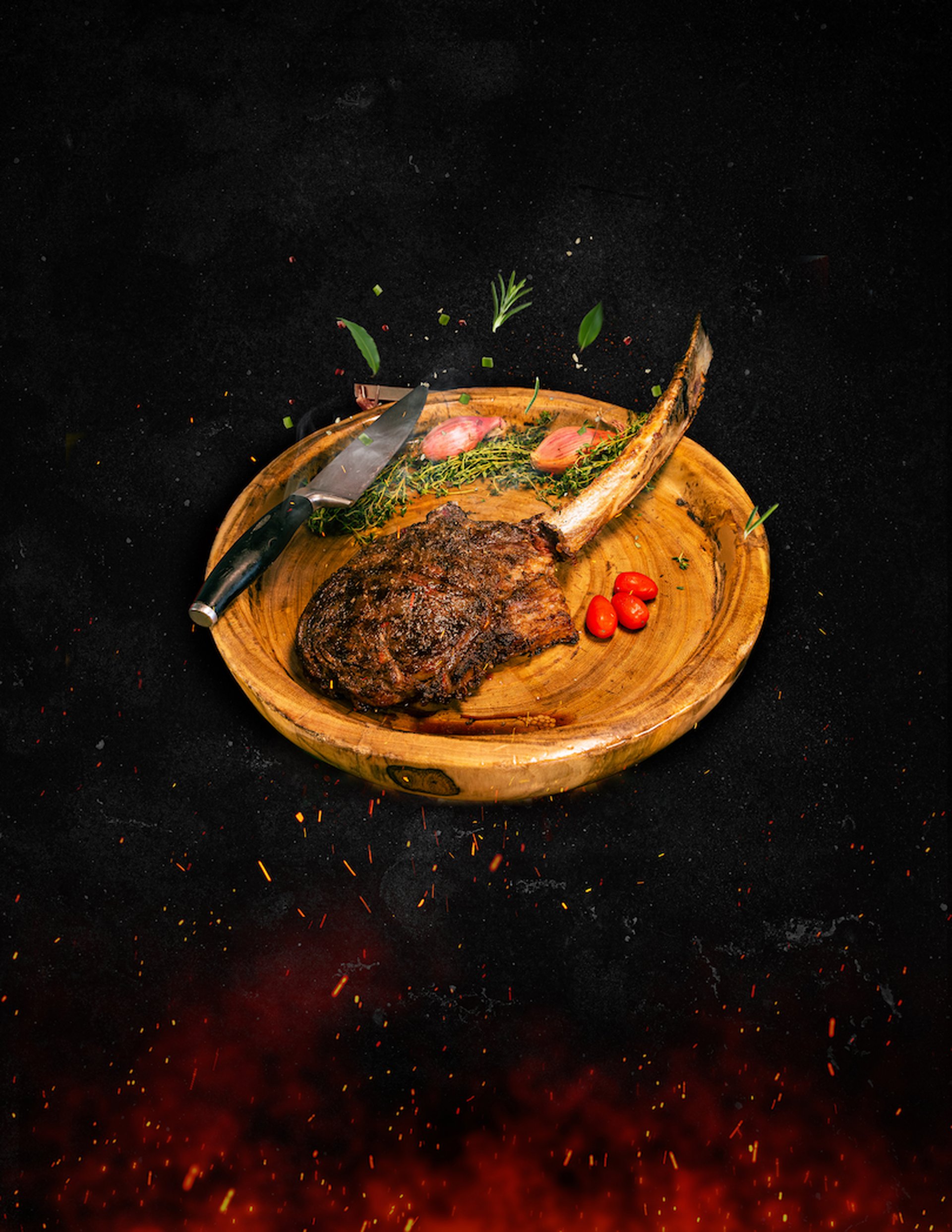 Gourmet tomahawk steak on a wooden board with herbs, shallots and cherry tomatoes over ember-lit black backdrop, Garza Blanca Puerto Vallarta dining.