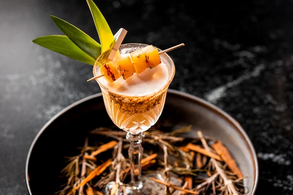 Garza Blanca cocktail — frothy, spice-rimmed coupe garnished with grilled pineapple skewers and tropical leaves. Escape to the Extraordinary.