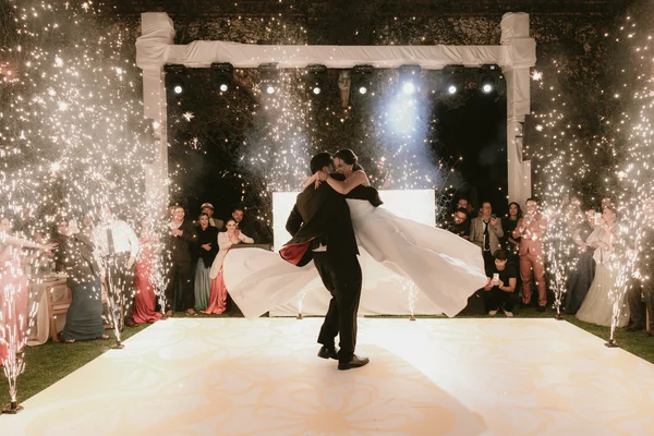 Primer baile de los novios en la pista rodeados de fuentes de chispas e invitados