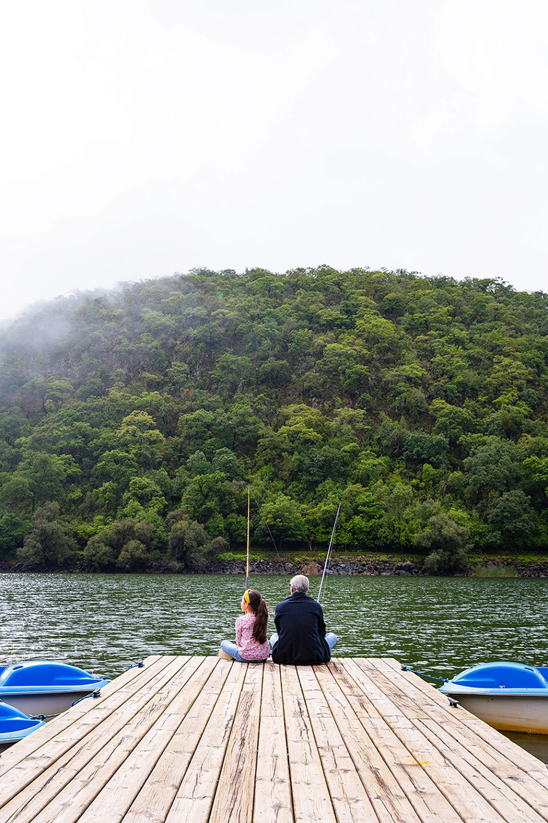 Person fishing from the lake dock