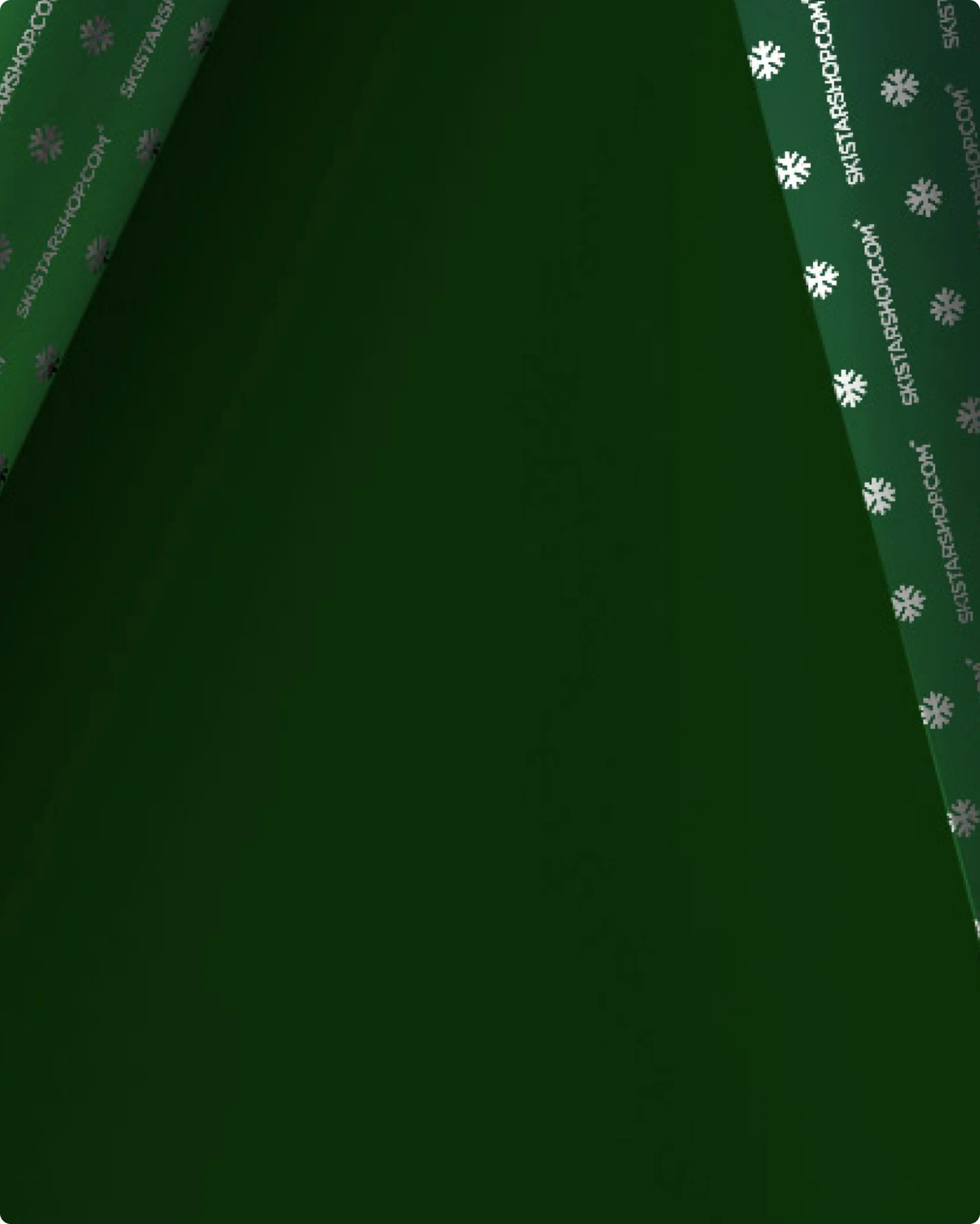 Dark green wrapping paper with a folded corner, revealing a pattern of white snowflakes.