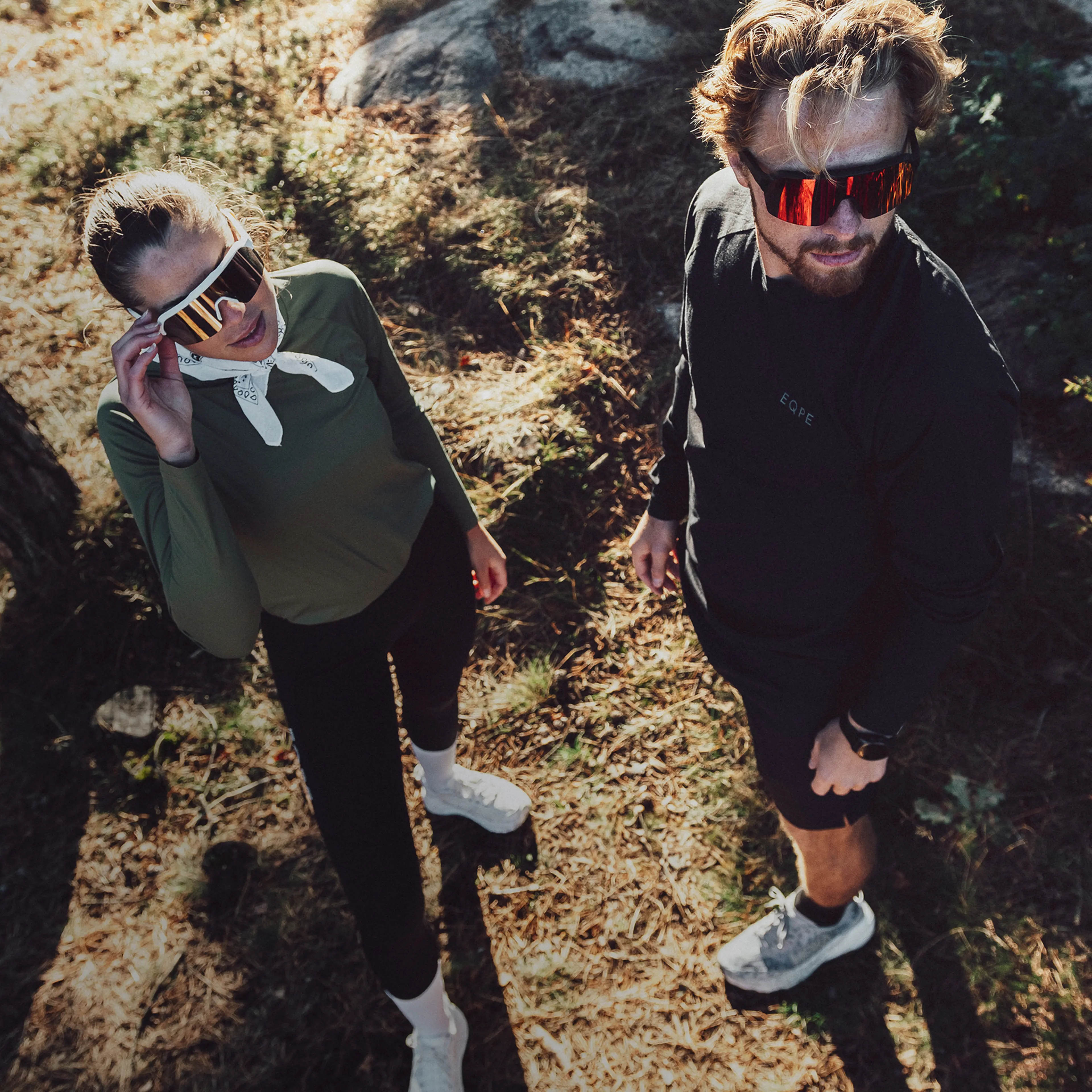 Two people wearing sporty sunglasses and running gear.