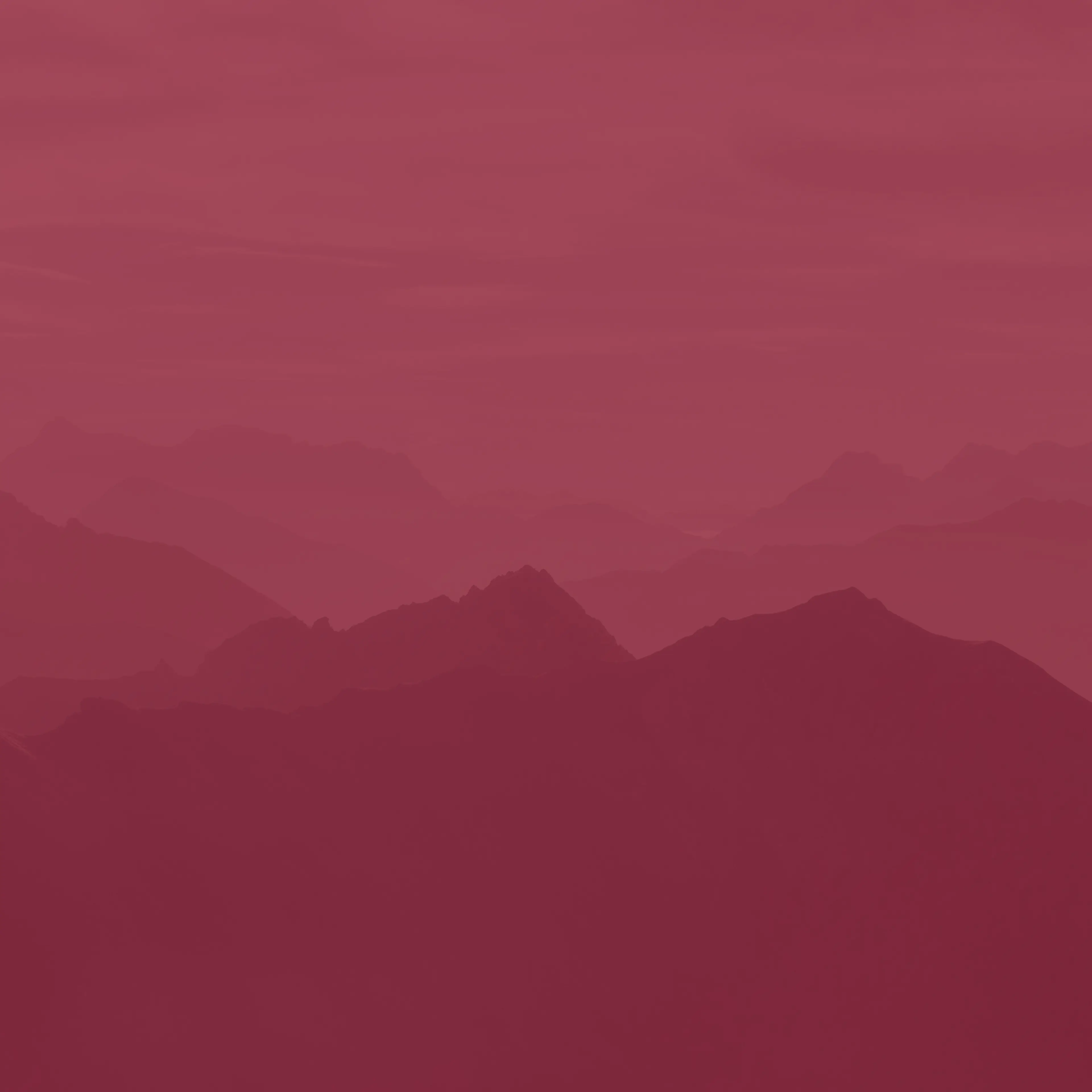 Silhouetted mountain range in shades of red, creating a layered and atmospheric landscape effect.