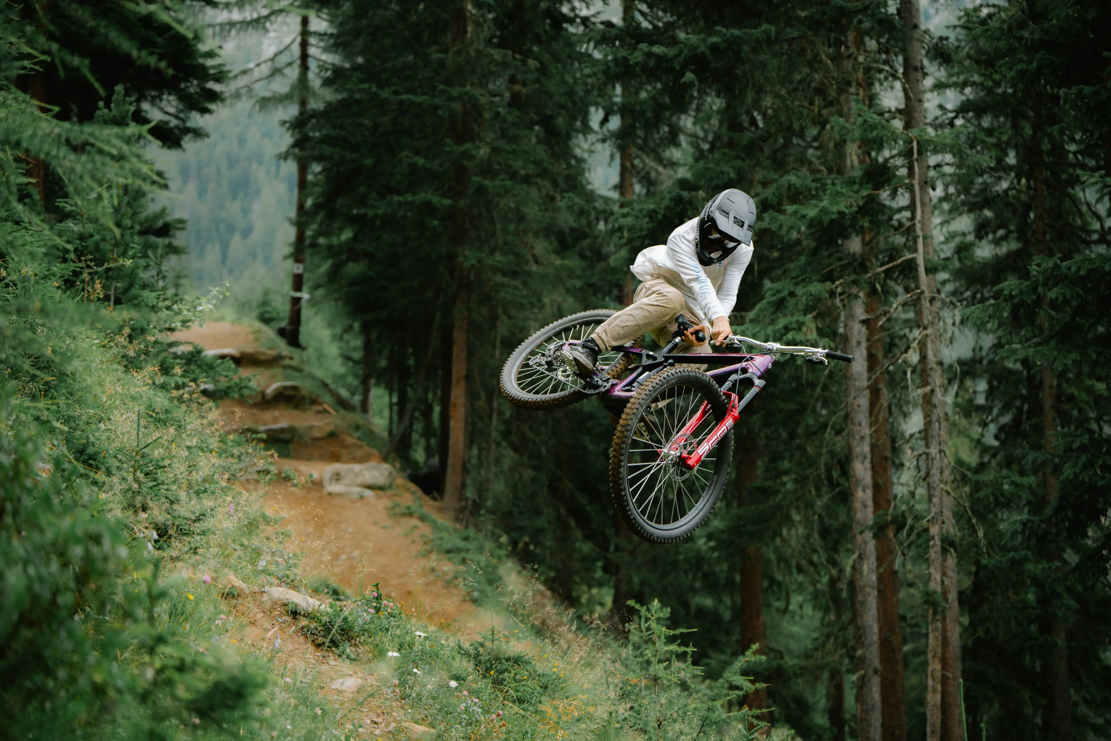 Downhill cyclist in the middle of a jump in the forest