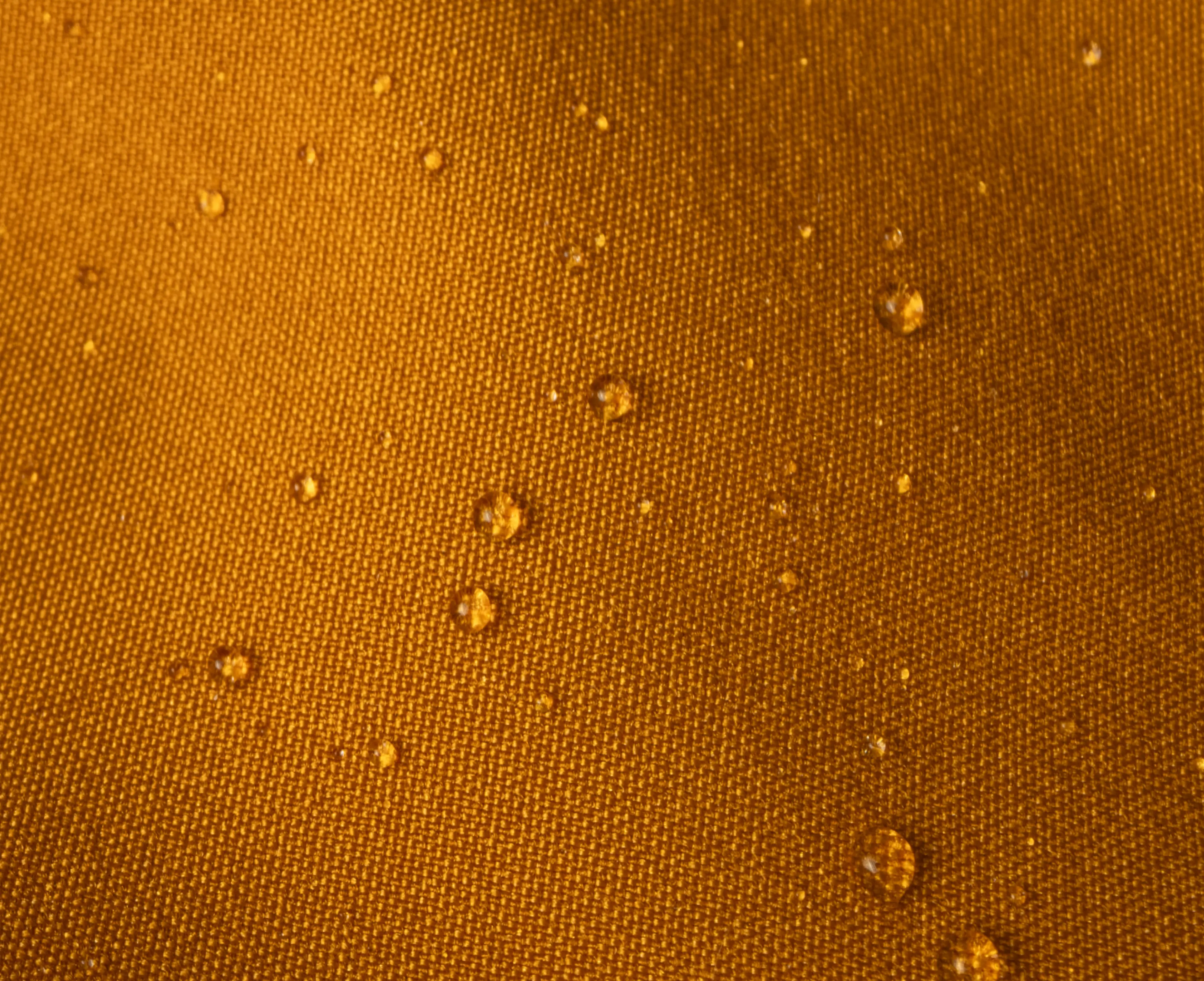Orange fabric with water droplets scattered across the surface