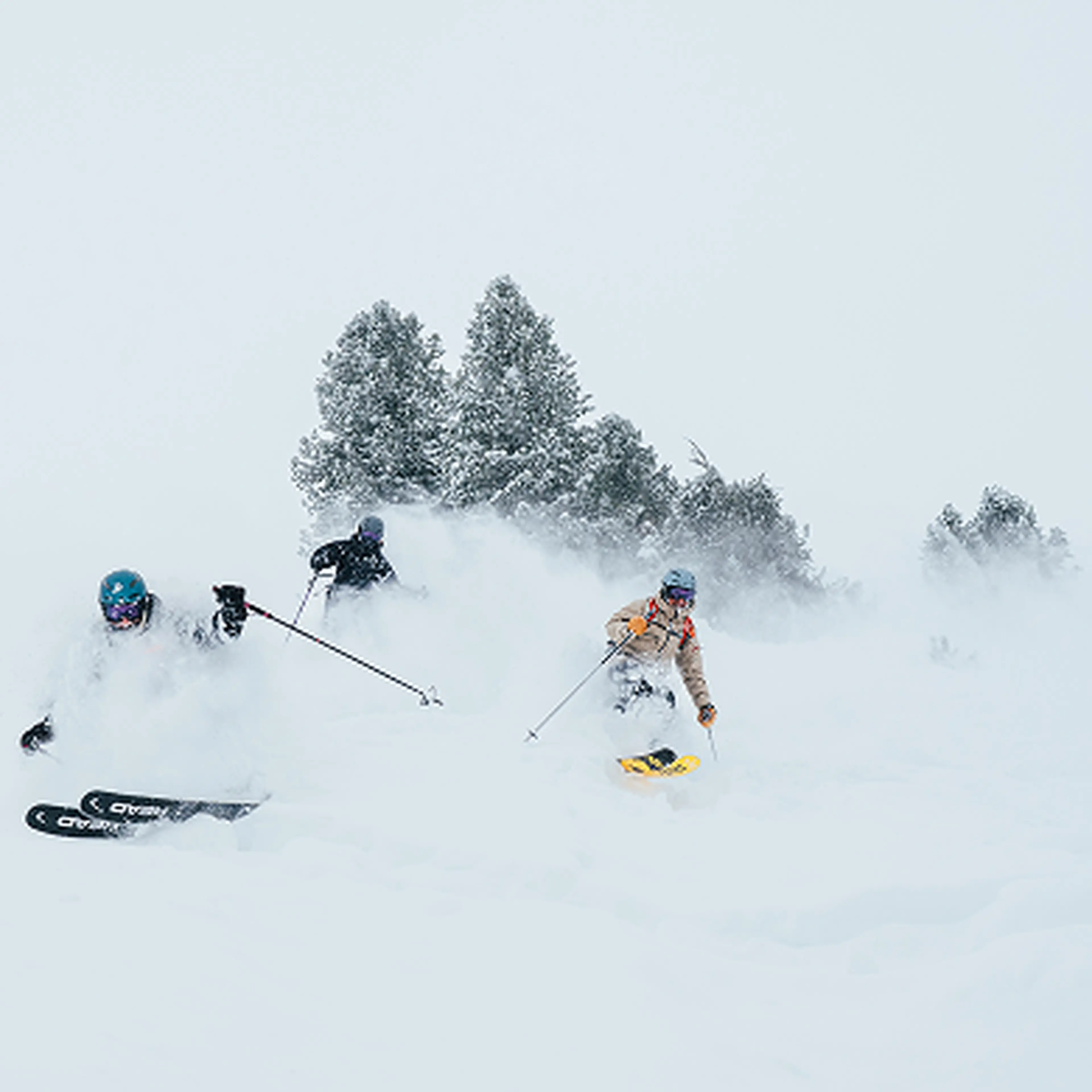 3 skiers going down deep snow