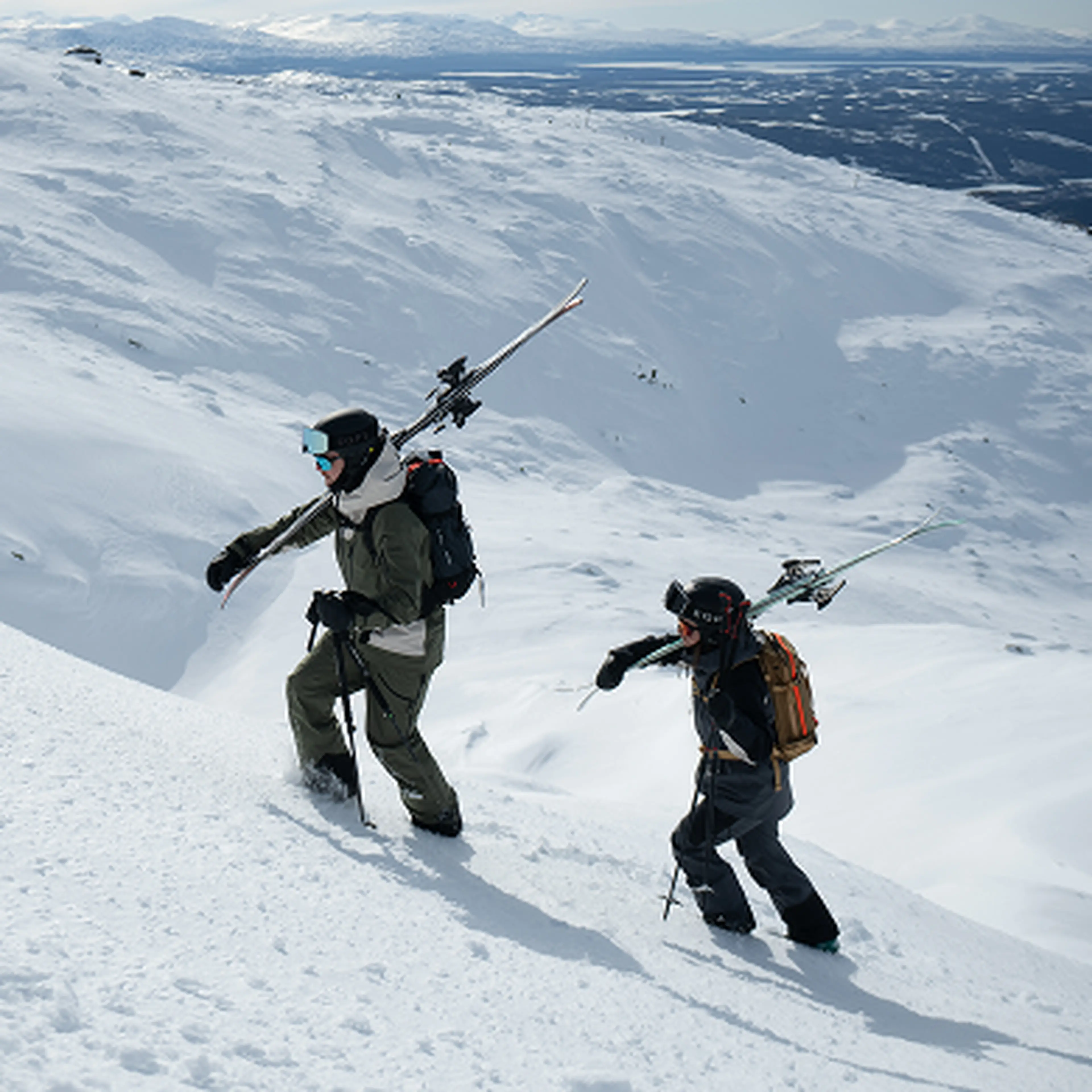 2 skiers hiking upp snowy mountain