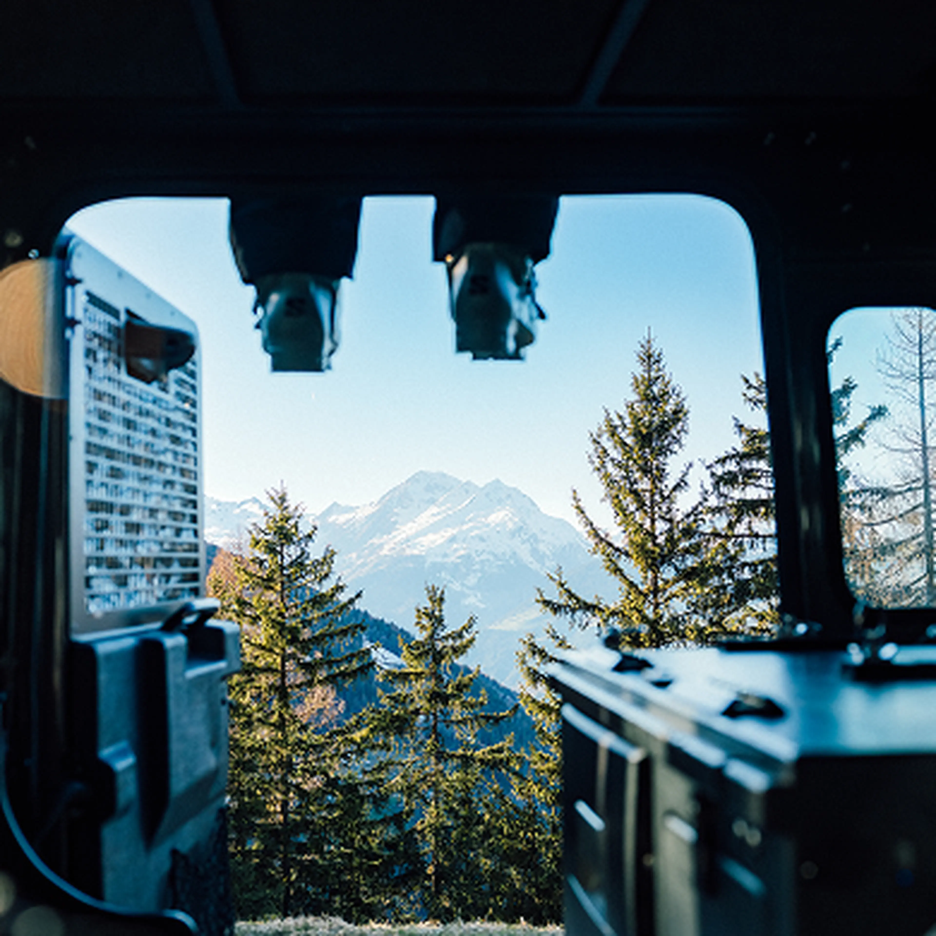 View out of car with background of mountains and feets hanging down