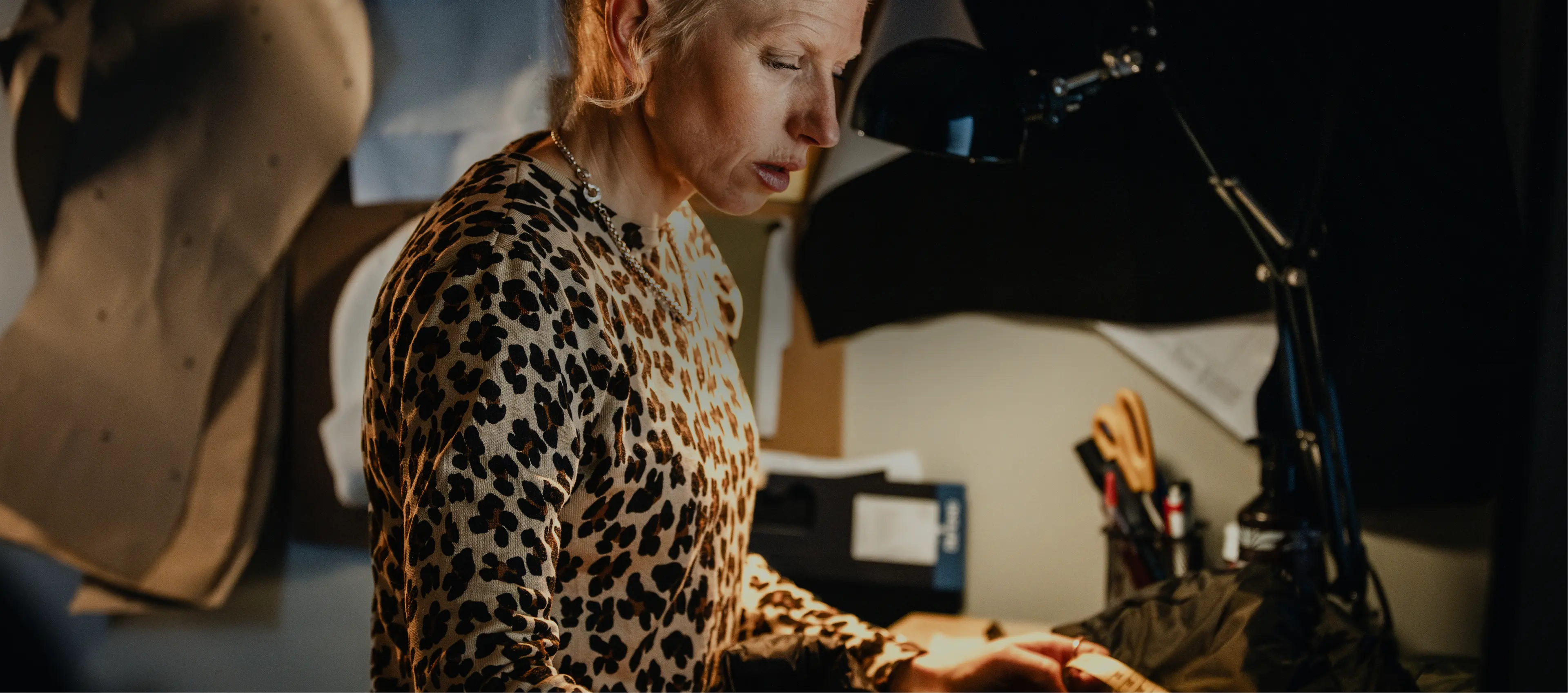 Sara working with a piece of clothing by her desk