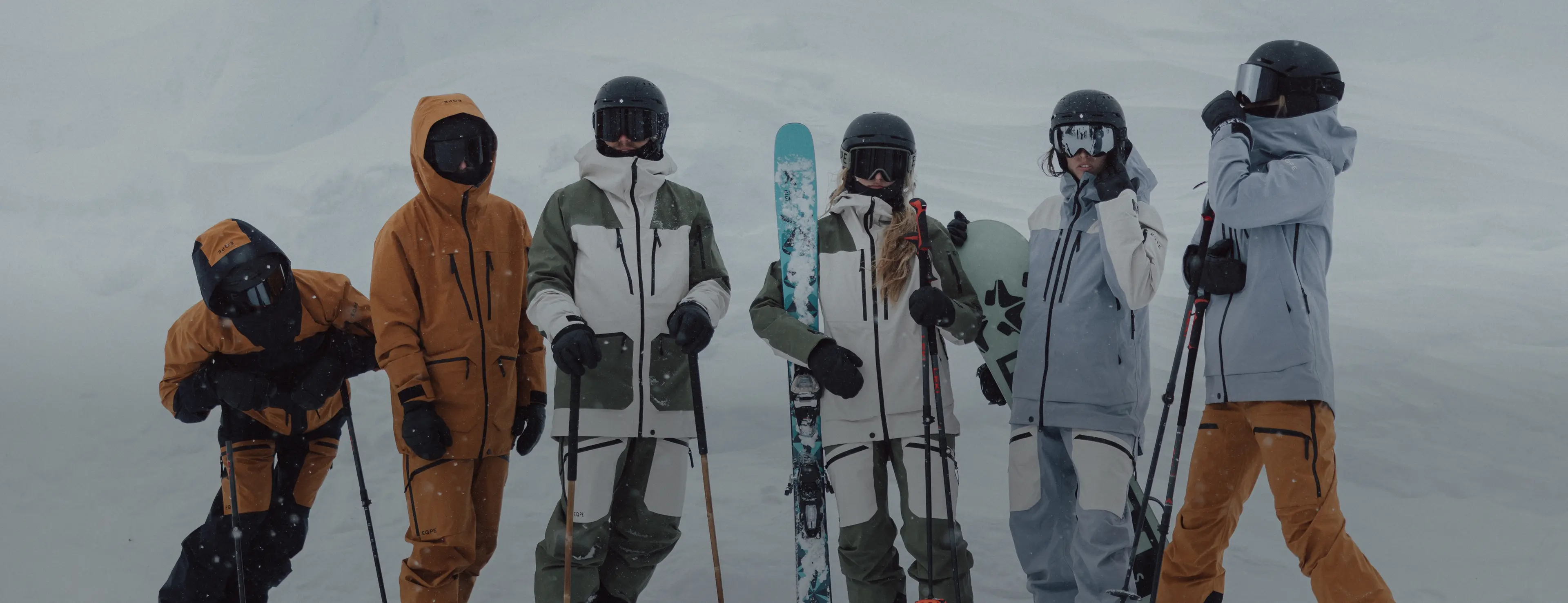 Group of people dressed in ski clothes standing in a snowy landscape