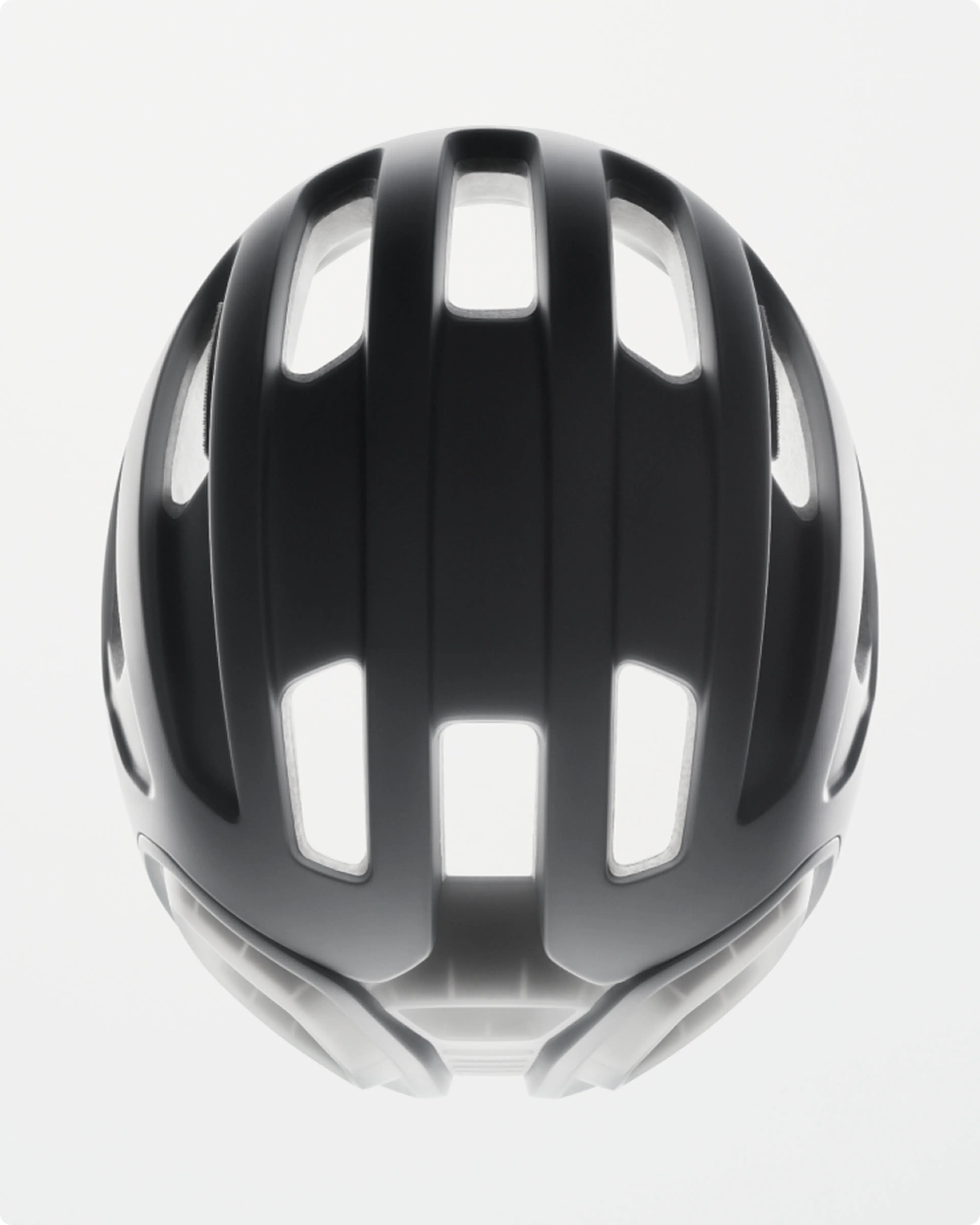 Black bike helmet with multiple elongated vents, viewed from above, against a plain white background.
