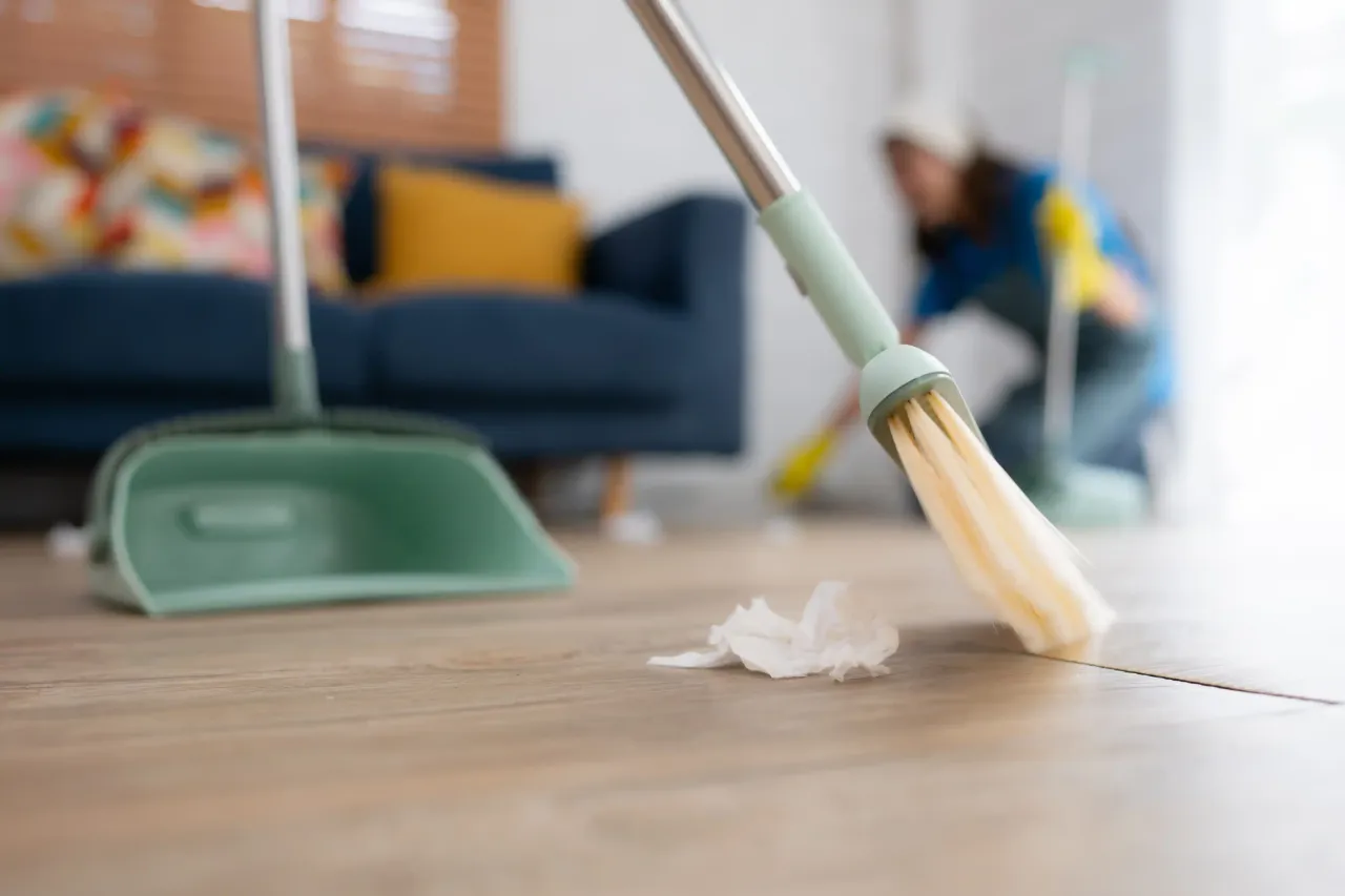 Professional cleaners from Reliable Cleans performing detailed residential house cleaning, including dusting, vacuuming, and sanitizing a modern living room.