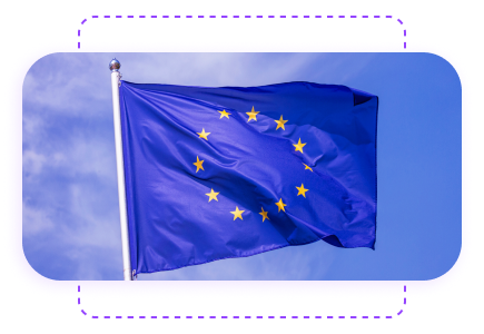 European Union flag with twelve gold stars on a blue background, flying against a clear sky.