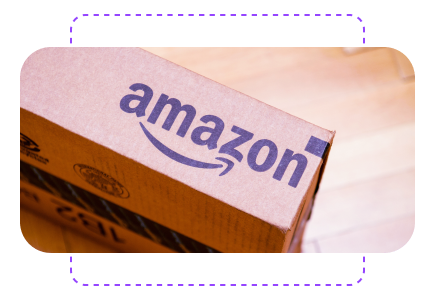 A cardboard box with the Amazon logo in blue on a wooden floor.