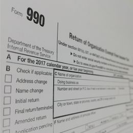 Close-up of IRS Form 990, titled "Return of Organization Exempt From Income Tax," showing sections for organization details and tax year.