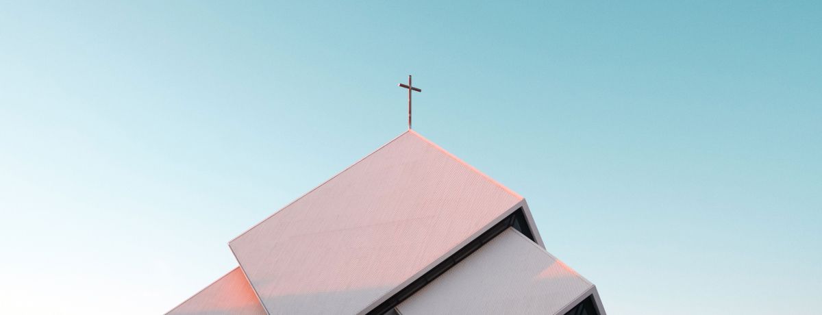 Modern church building with a cross on the roof against a clear blue sky, representing the type of faith-based organizations served by BMWL’s accounting and assurance services.