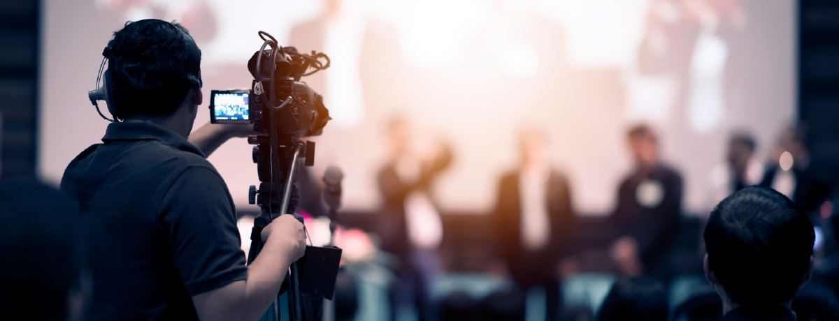 Videographer operating a camera to film a live stage event, representing media and film organizations served by our accounting firm’s nonprofit services.