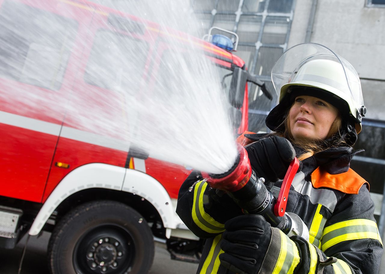 Frau die einen Wasserschlauch hält